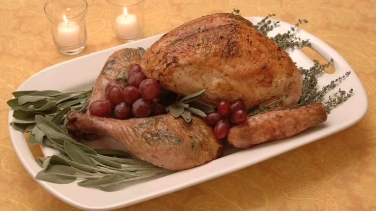 Dismantled turkey with thyme, butter and sage.