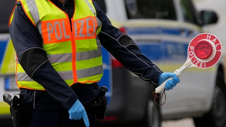 A German federal police officer stops cars and trucks at...