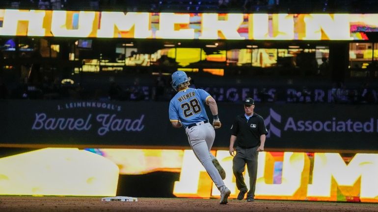 Milwaukee Brewers' Joey Wiemer rounds the bases after hitting a...