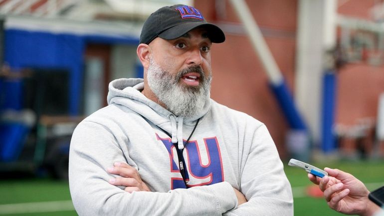 Giants offensive line coach Bobby Johnson speaks before practice at the...