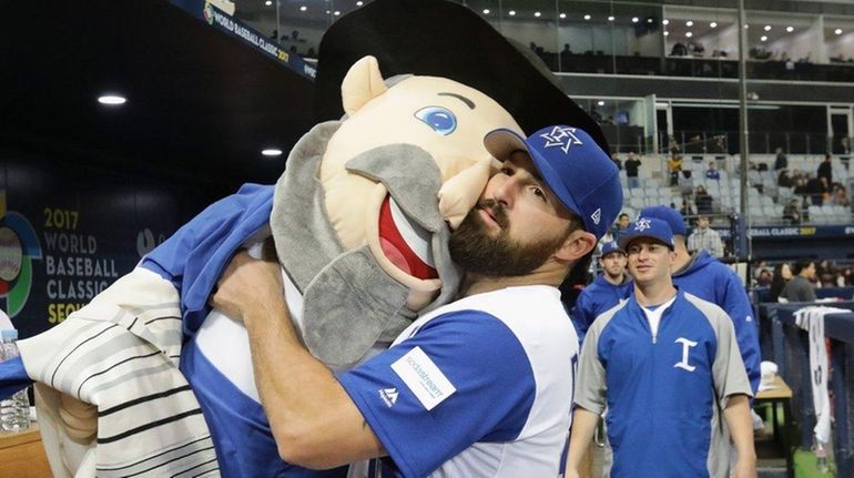 Infielder Cody Decker holds Israel's team mascot The Mensch after...