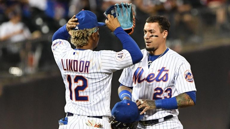 Mets second baseman Javier Baez and shortstop Francisco Lindor talk between...