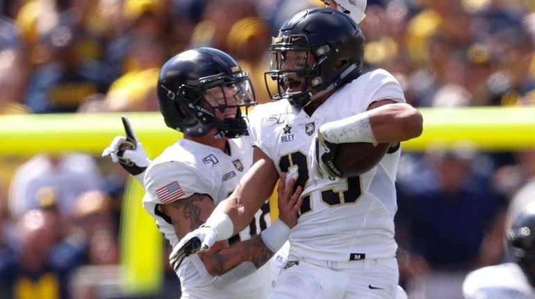 Army defensive back Elijah Riley celebrates after recovering a fumble...