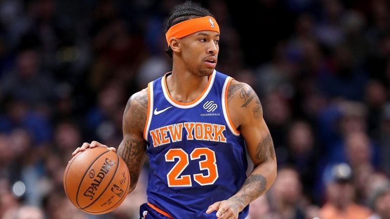 Trey Burke of the Knicks brings the ball down the...