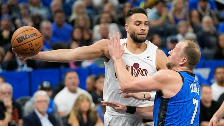 Cleveland Cavaliers guard Max Strus, left, passes the ball around...