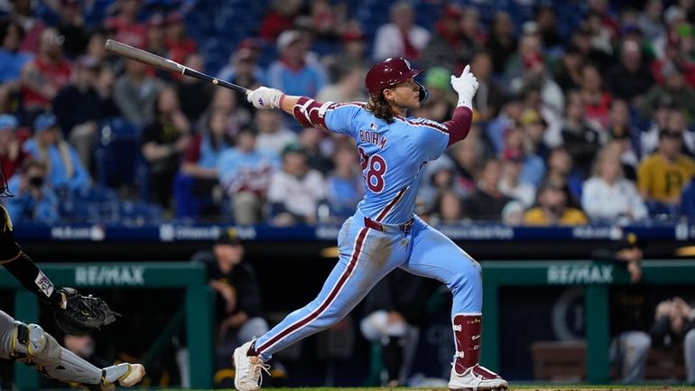 Philadelphia Phillies' Alec Bohm follows through after hitting a home...