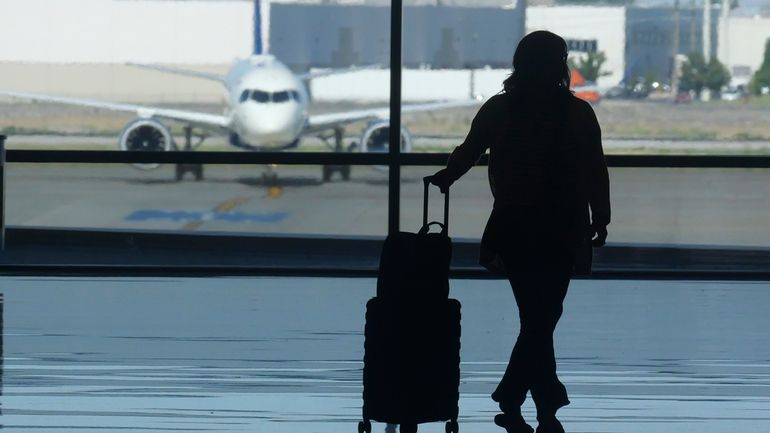 A holiday traveler looks out at a aeroplane at Salt...