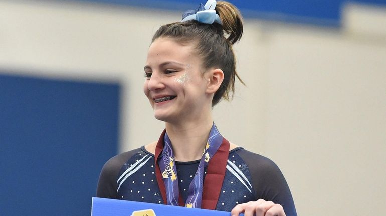 Hannah Hughes of Middle Country stands atop the podium after...