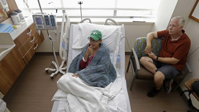 Bev Veals, left, undergoes chemotherapy treatment, accompanied by her husband...