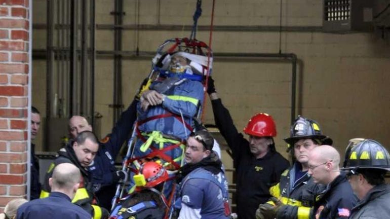 Firefighters from three departments rescue a man who fell down...