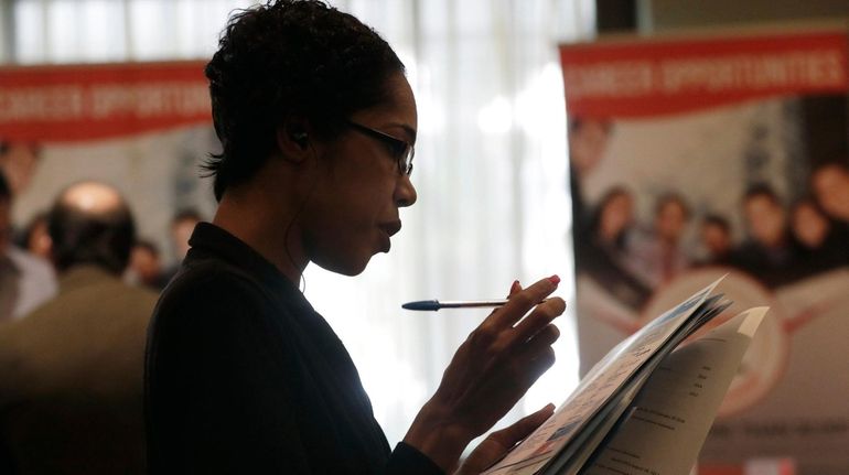 Joana Dudley, of Lauderhill, Fla., looks at her list of...