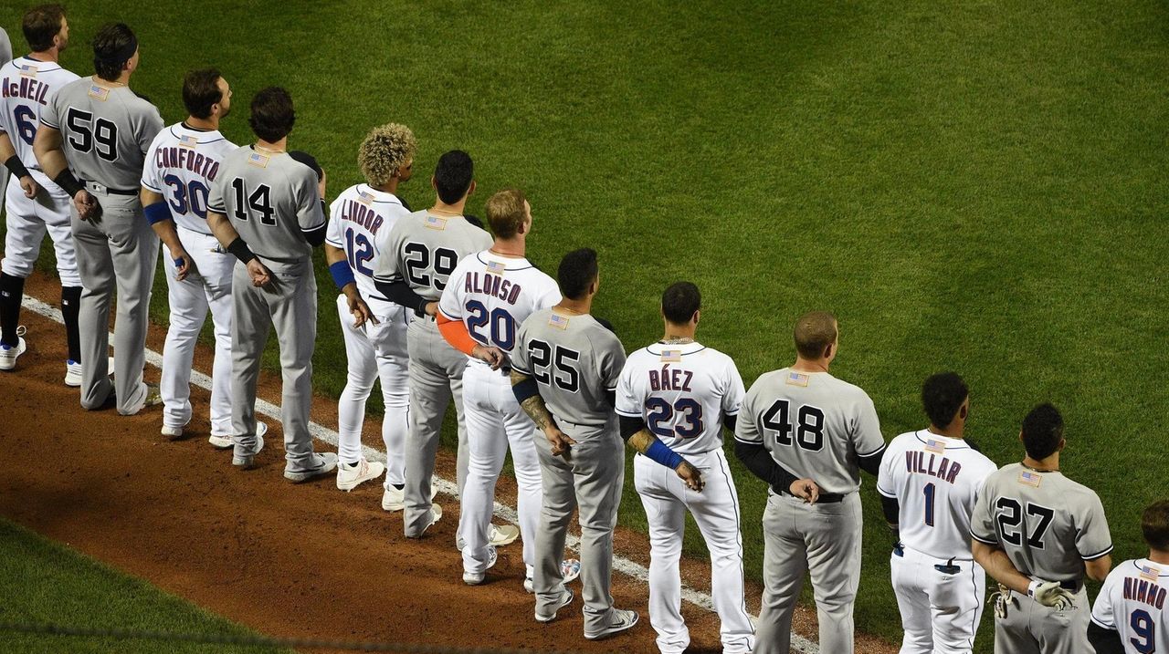 The New York Yankees and the New York Mets shake hands before lining up  together along the baselines for the 20th anniversary of the 9/11 terrorist  attacks before a baseball game on