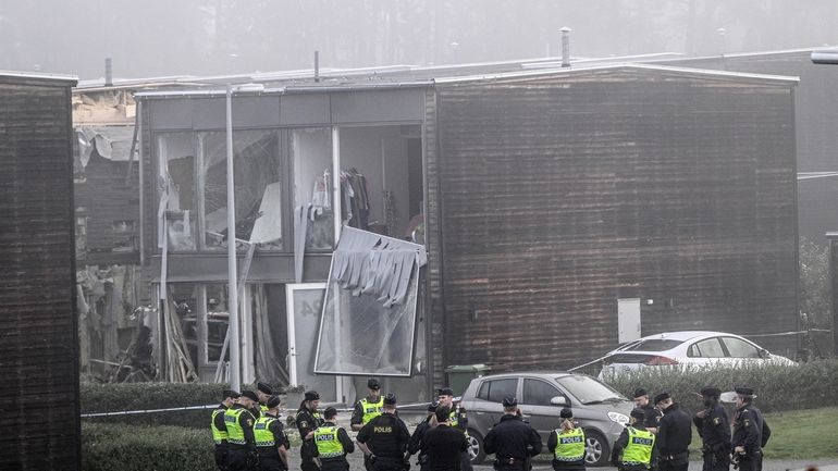 Police stand on the site of a powerful explosion that...