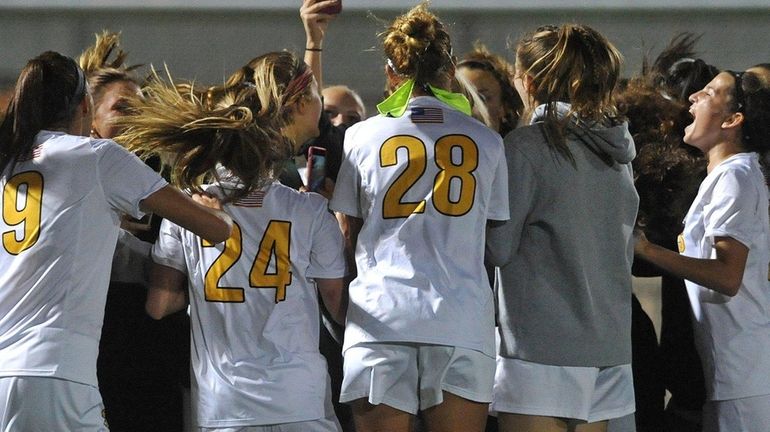 St. Anthony's teammates celebrate after their win over Sacred Heart...