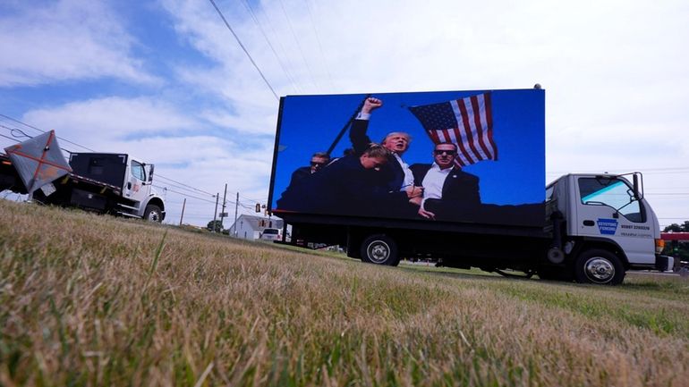 An electronic billboard displays images of former President Donald Trump...