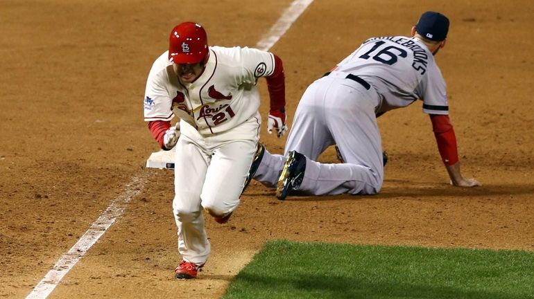 St. Louis Cardinals baserunner Allen Craig runs after being tripped...