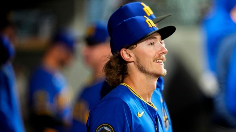 Seattle Mariners starting pitcher Bryce Miller stands in the dugout...