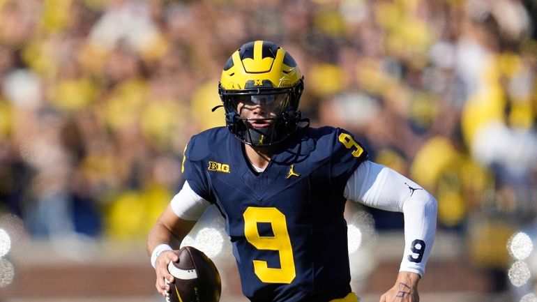 Michigan quarterback J.J. McCarthy (9) looks to throw against UNLV...