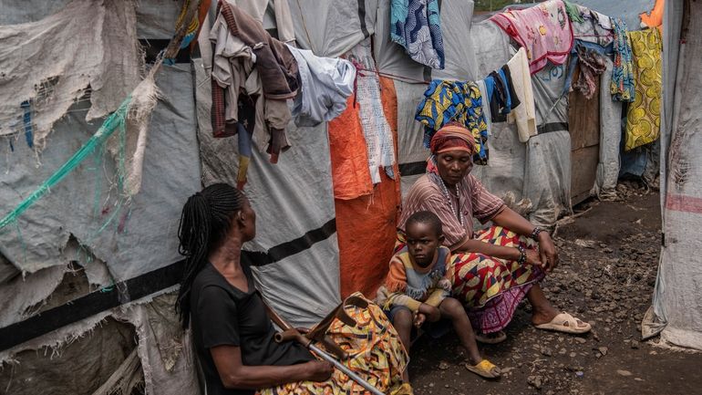 People sit at the Don Bosco refugee camp as Red...