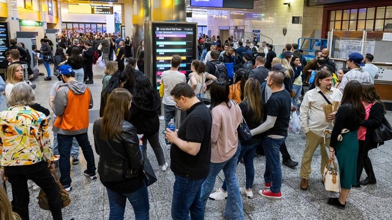 Madison Square Garden concertgoers and late-night commuters wait to board...