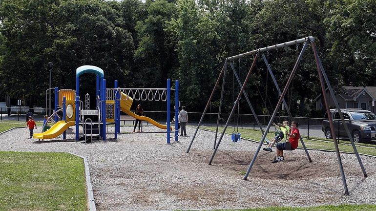 Parents and children playing in Robert J. Henke Park is...