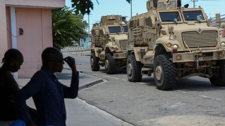 Kenyan police officers, part of a UN-backed multinational force, drive...