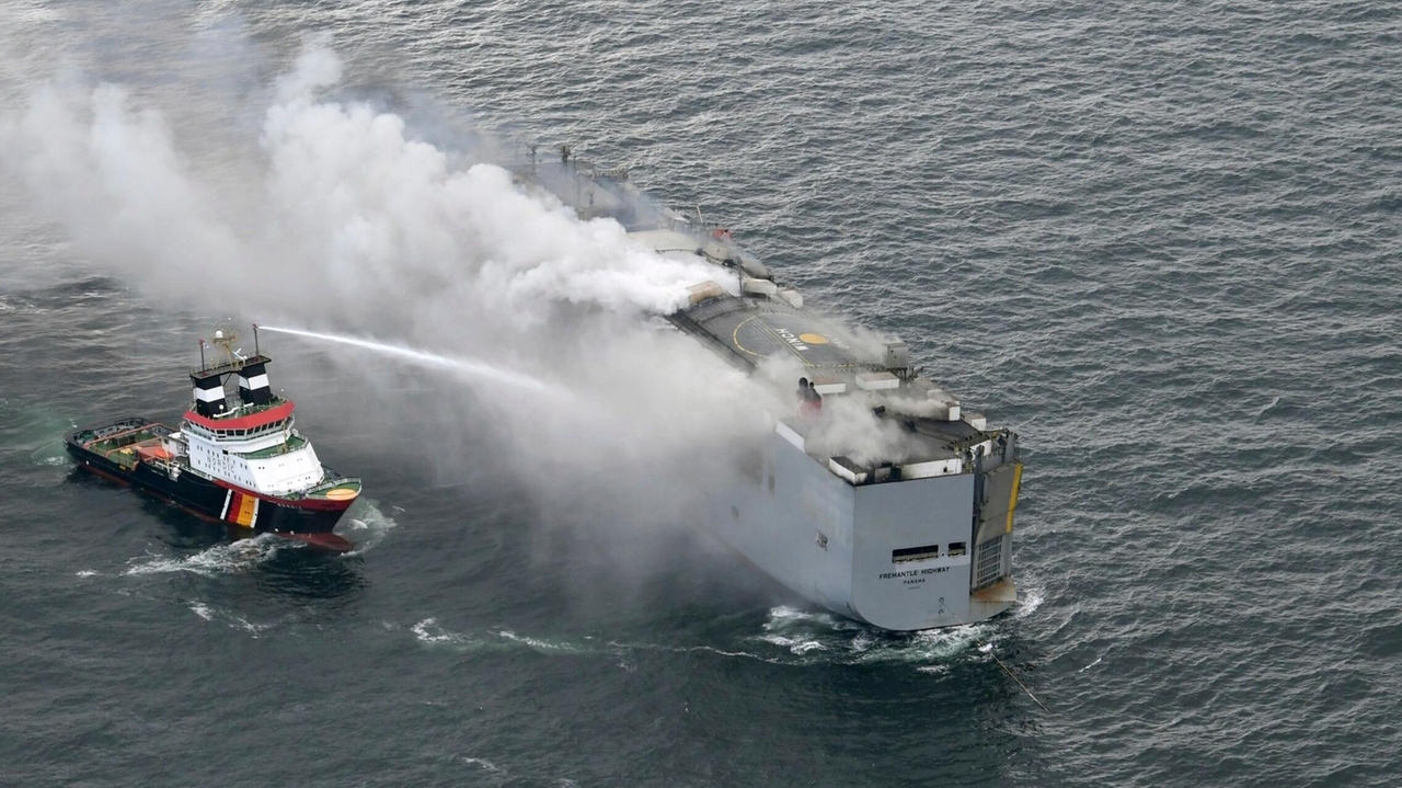 A freighter carrying nearly 3,000 cars catches fire in the North Sea and a crew member is killed