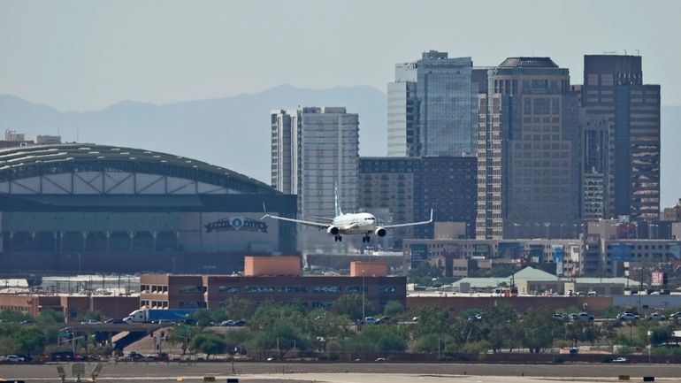 Downtown Phoenix is obscured by heat ripples as a jet...