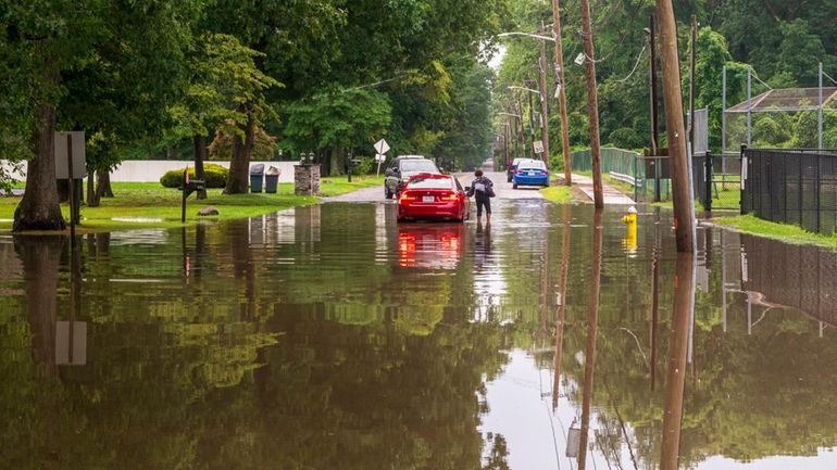 A motorist wades to safety after her car became disabled on...