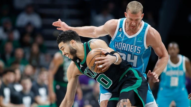 Boston Celtics forward Jayson Tatum (0) drives around Charlotte Hornets...