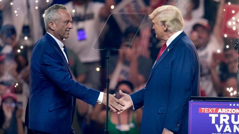 Independent presidential candidate Robert F. Kennedy Jr., left, shakes hands...