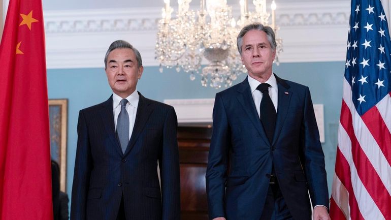 Secretary of State Antony Blinken, right, accompanied by China's Foreign...