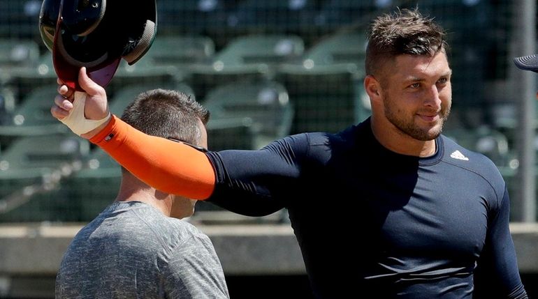 Former NFL quarterback Tim Tebow finishes his workout for baseball...