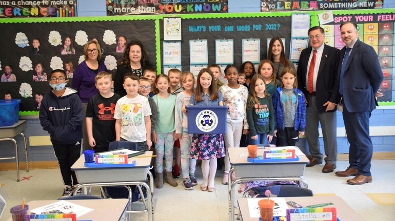 Kayla Zatyk, holding the banner, is a third-grader at Lynwood...