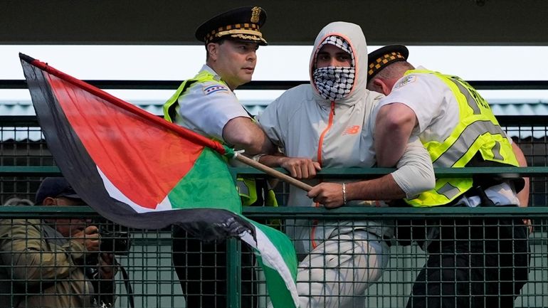 Police detain a protester during a demonstration outside the Democratic...