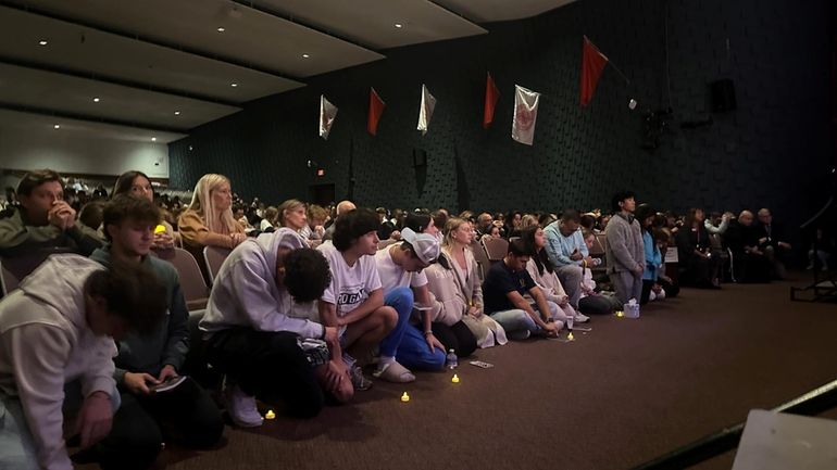 Students and parents attend a candle light vigil Monday at St John...