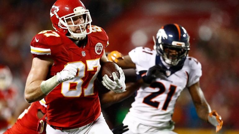 Kansas City Chiefs' player Travis Kelce (L) runs the ball...