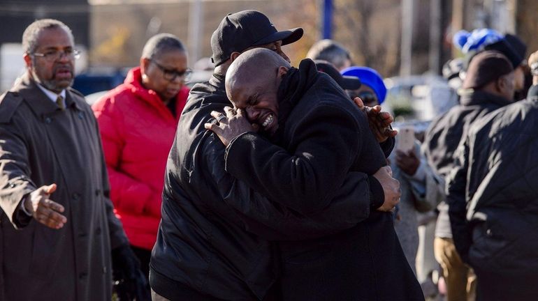 Ronald Lanier sobs on the shoulder of a friend before...