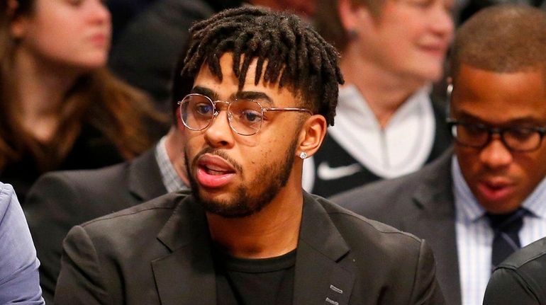 The Nets' D'Angelo Russell looks on from the bench in...