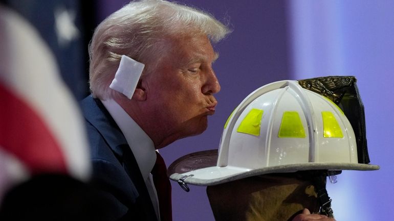 Republican presidential candidate former President Donald Trump kisses the helmet...