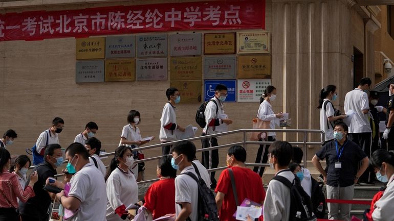 Students line up to enter a school for the first...