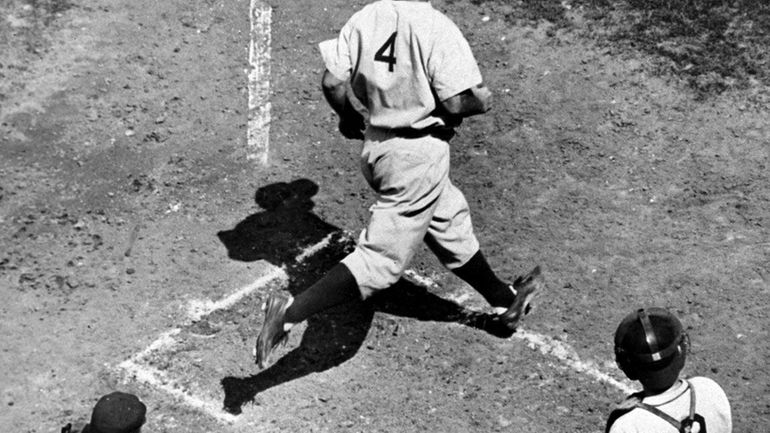 Lou Gehrig, first baseman of the New York Yankees, crosses...