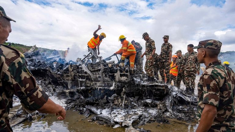 Nepal army personnel sort through the debris after a domestic...