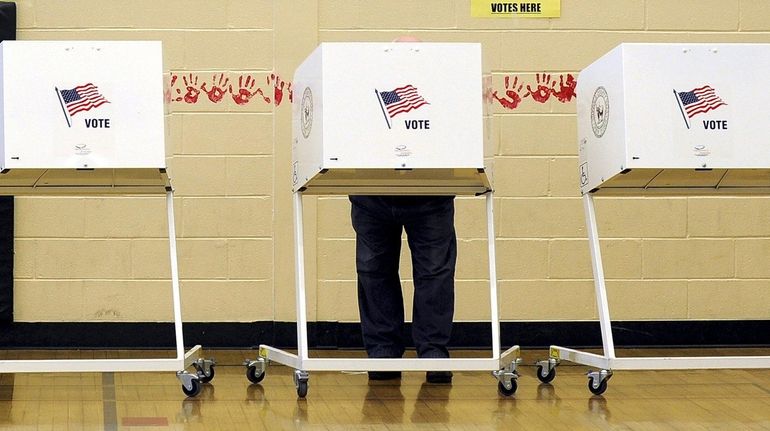 A voter in a booth on Election Day, Nov. 8, 2011,...