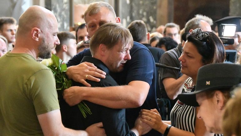 Friends hug Yaroslav Bazylevych during the funeral service for his...