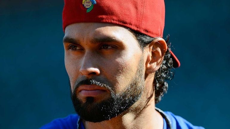 Puerto Rico's Angel Pagan watches Japan take batting practice before...