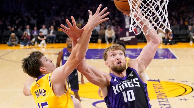 Sacramento Kings forward Domantas Sabonis, right, shoots as Los Angeles...