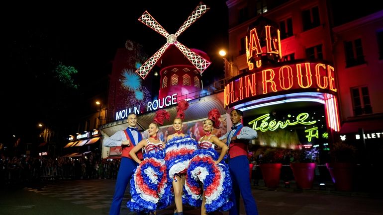 Dancers perform in front of the Moulin Rouge cabaret during...