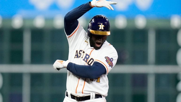 Houston Astros' Yordan Alvarez reacts after hitting a three-run double...