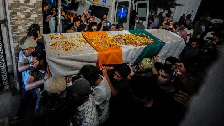 Relatives and colleagues carry the coffin of Indian police officer...